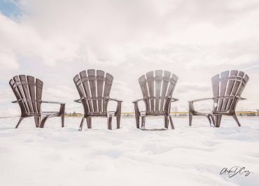 Muskoka chairs lined up in a snow-filled park in Oakville