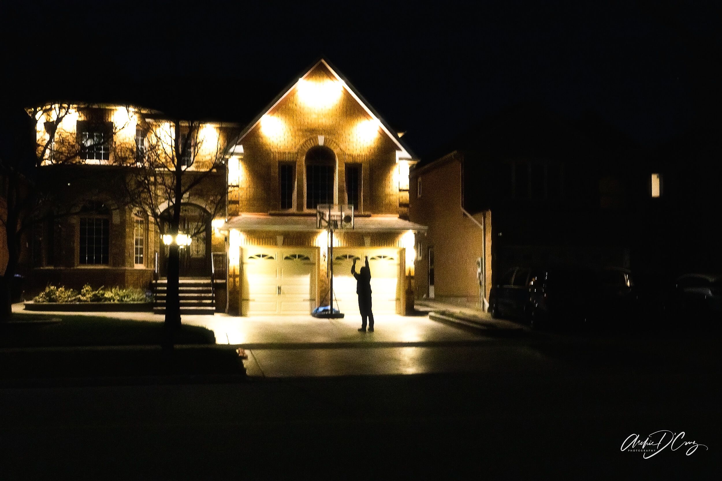 Teenager playing basketball on driveway