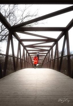 A woman crosses the bridge at Erindale Park